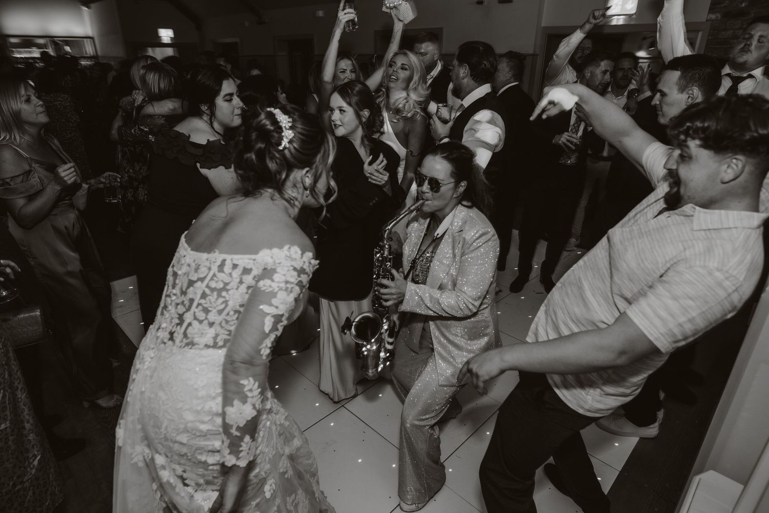 Black and white reception photo of wedding guests dancing and celebrating. Apton Hall