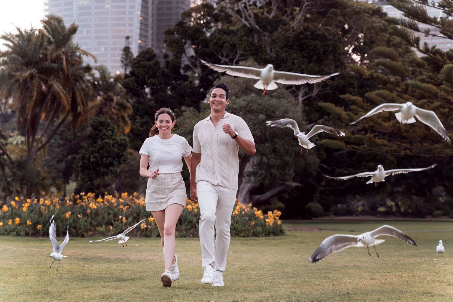 Couple running among the seagulls in Sydney for a fun Valentine's day photoshoot