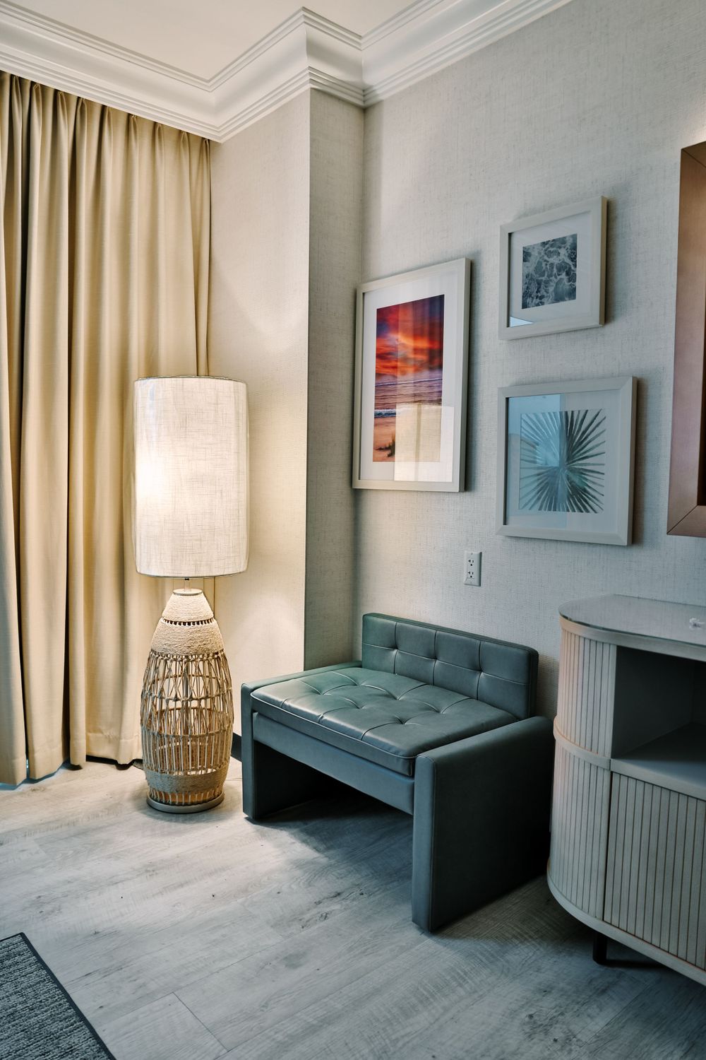 Stylish waiting area with teal accent furniture, modern lamp, and framed artwork on neutral walls.
