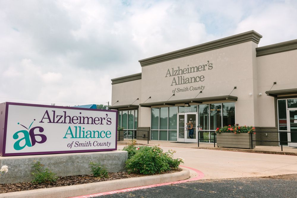 Modern medical facility exterior with Alzheimer's Alliance signage and landscaping.