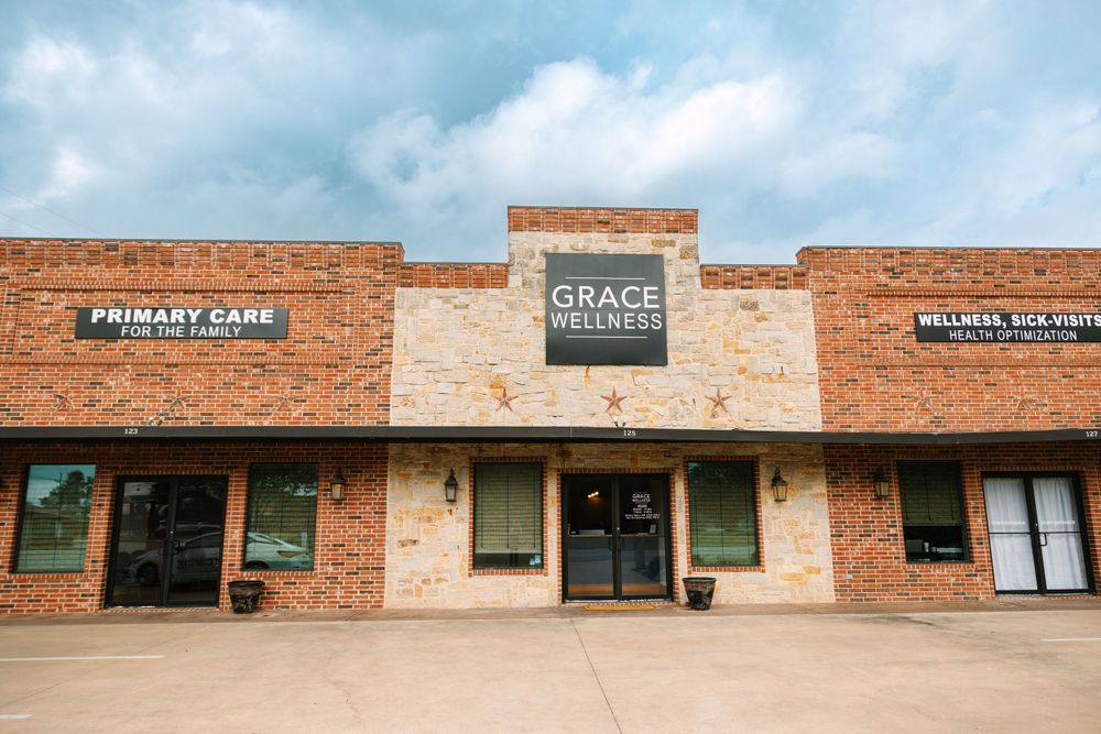Strip mall exterior with brick facade featuring Grace Wellness and other business signage.