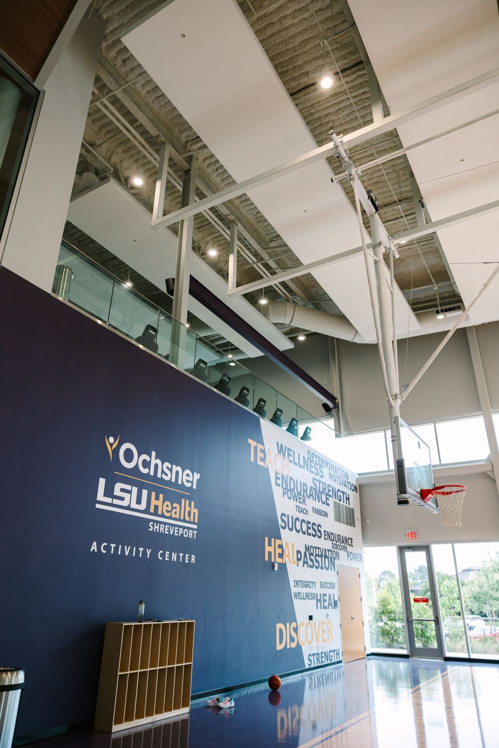 High-ceiling activity center with inspirational wall graphics and industrial architectural details.