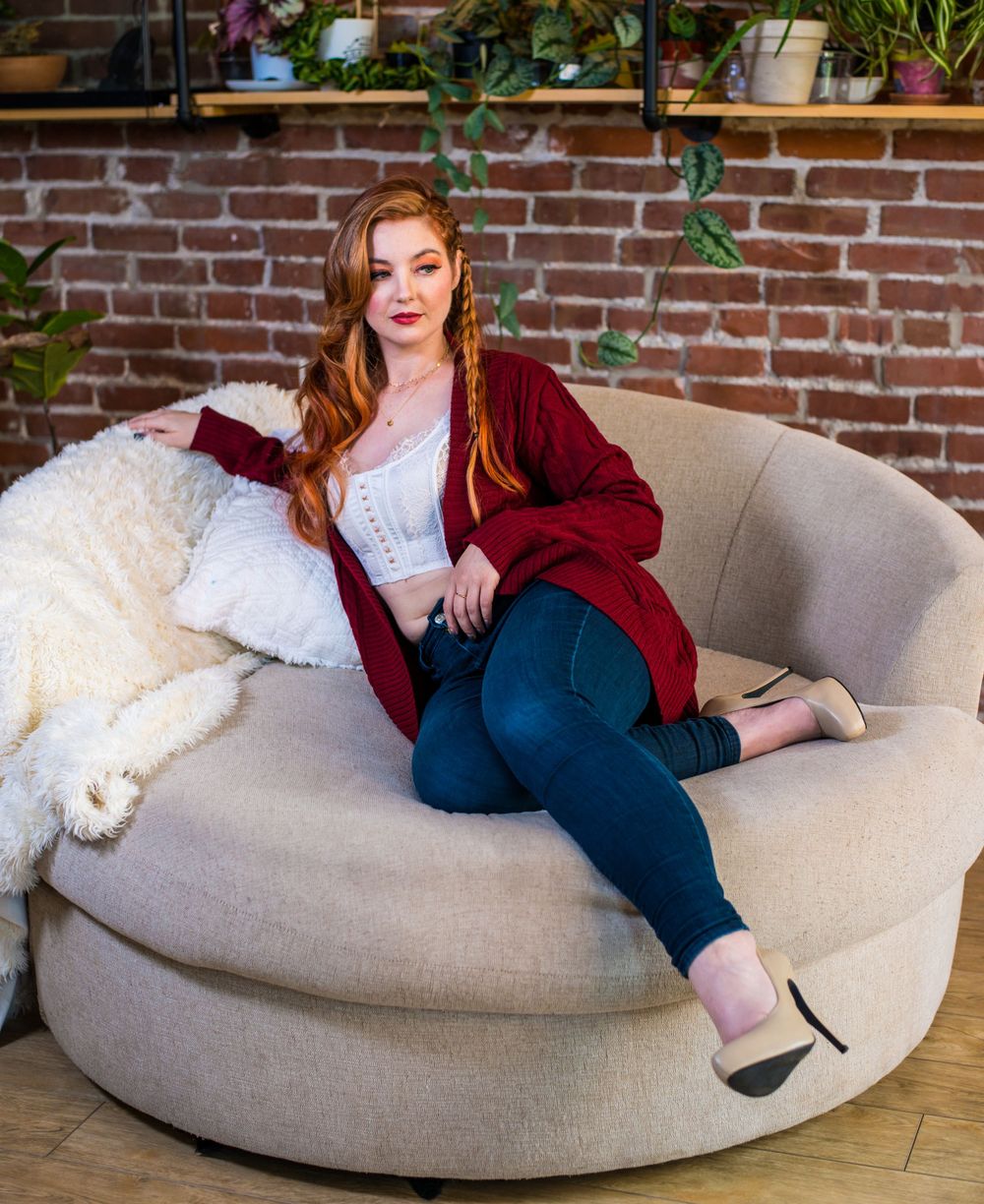 Casual indoor scene on grey bean bag chair with brick wall background.