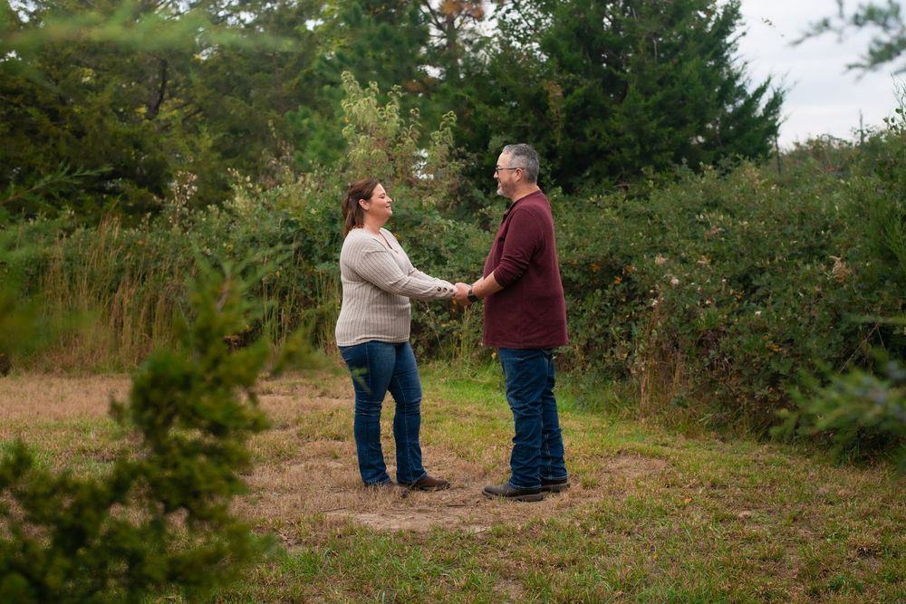 Couple dancing together in a natural outdoor setting surrounded by greenery.