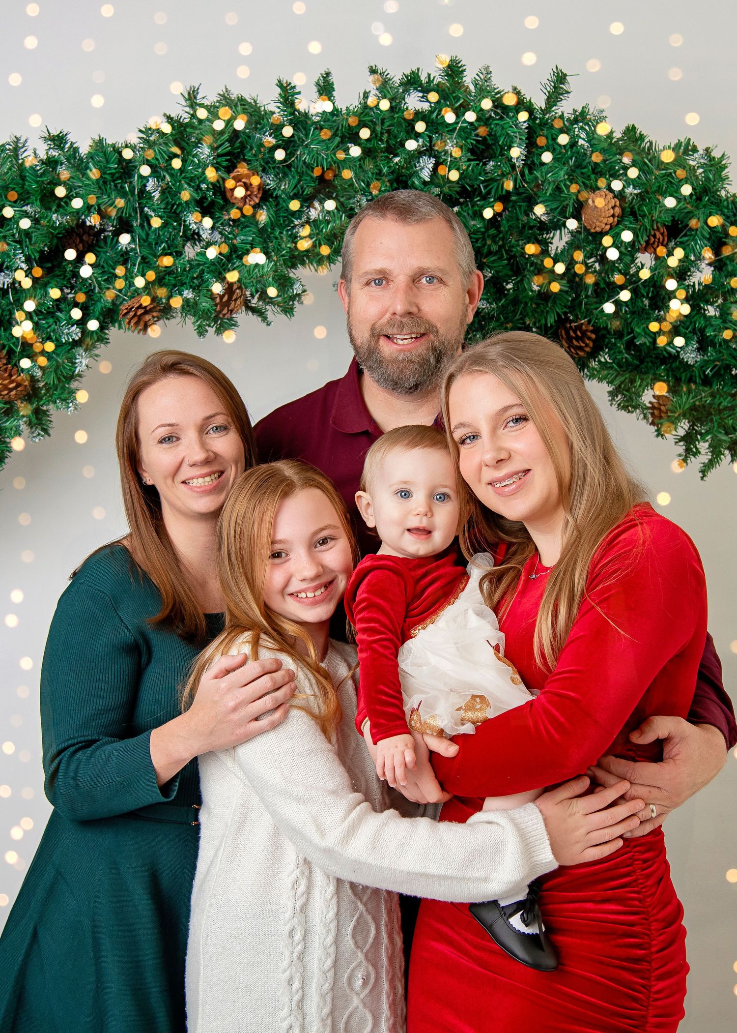 Holiday portrait with Christmas garland and lights backdrop.