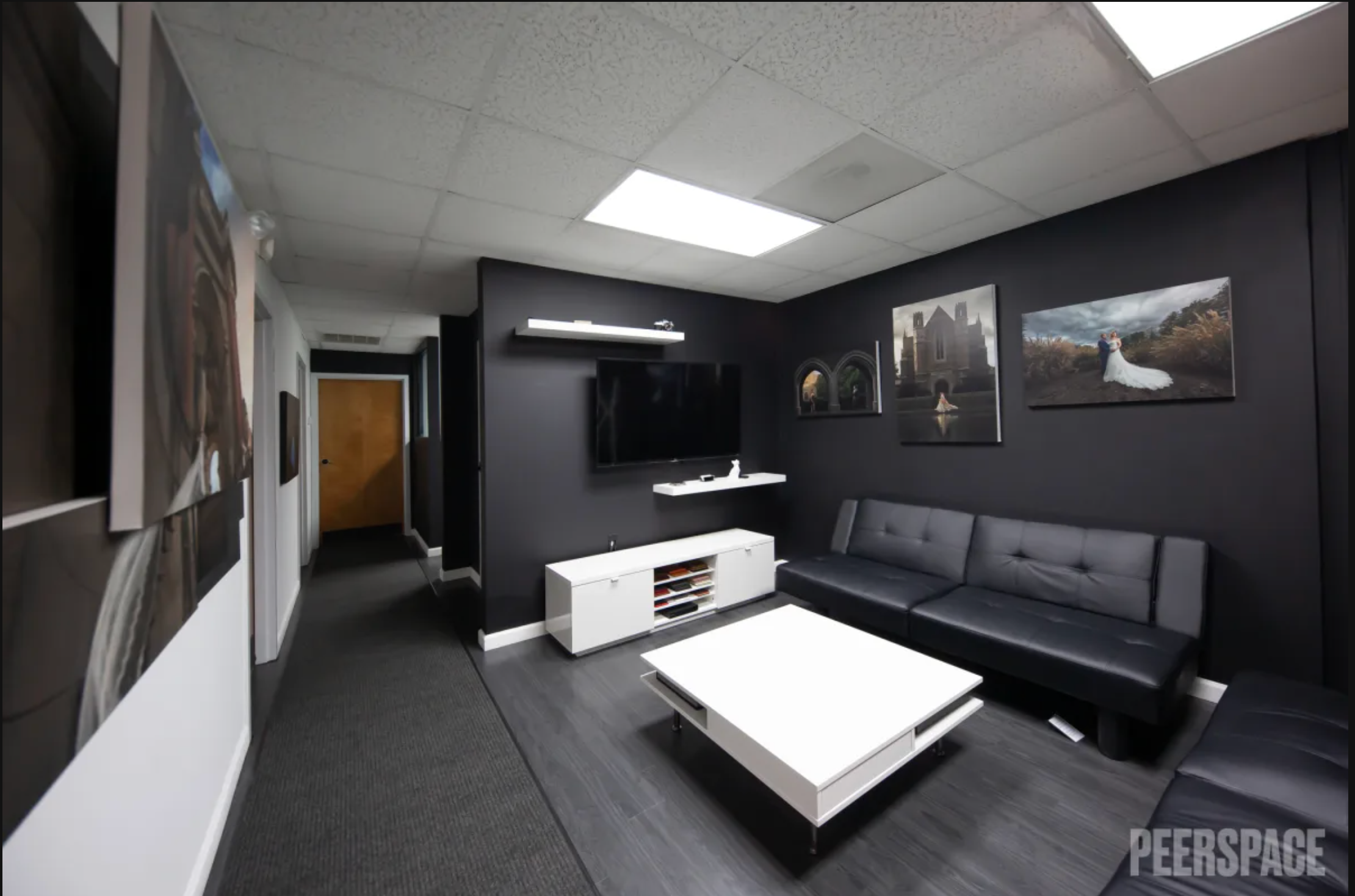 Modern office interior with dark walls and minimalist design features skylight illumination.