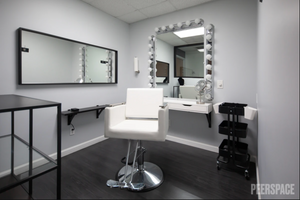 Professional photography studio interior with makeup station and mirror lighting.