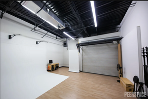Modern photography studio interior with white walls and overhead lighting.