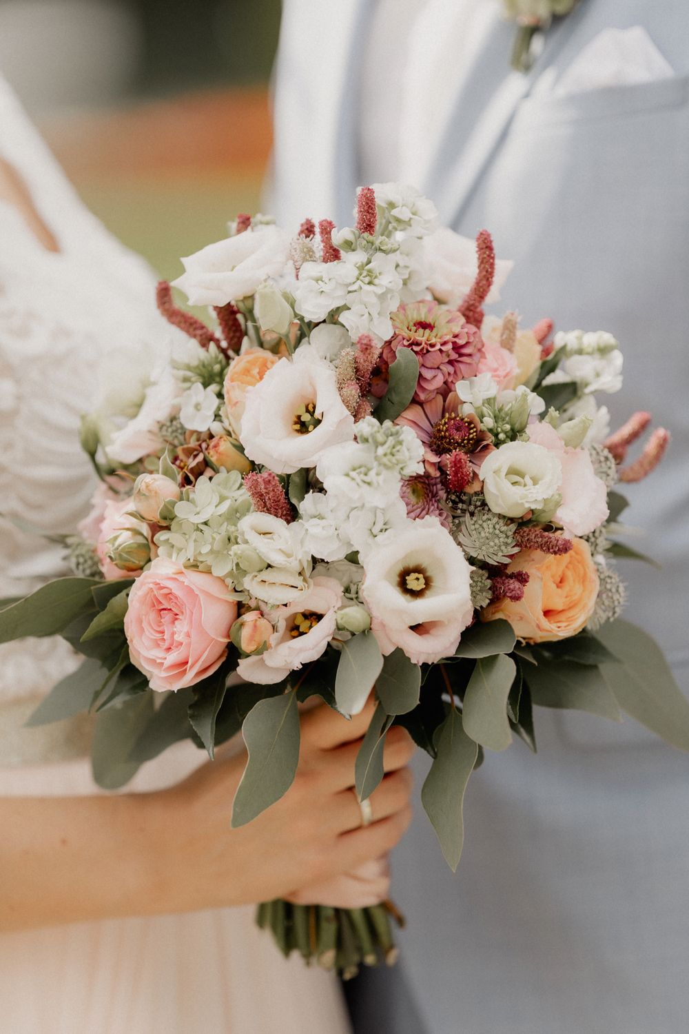 Elegant wedding bouquet with pink and white flowers and eucalyptus leaves.
