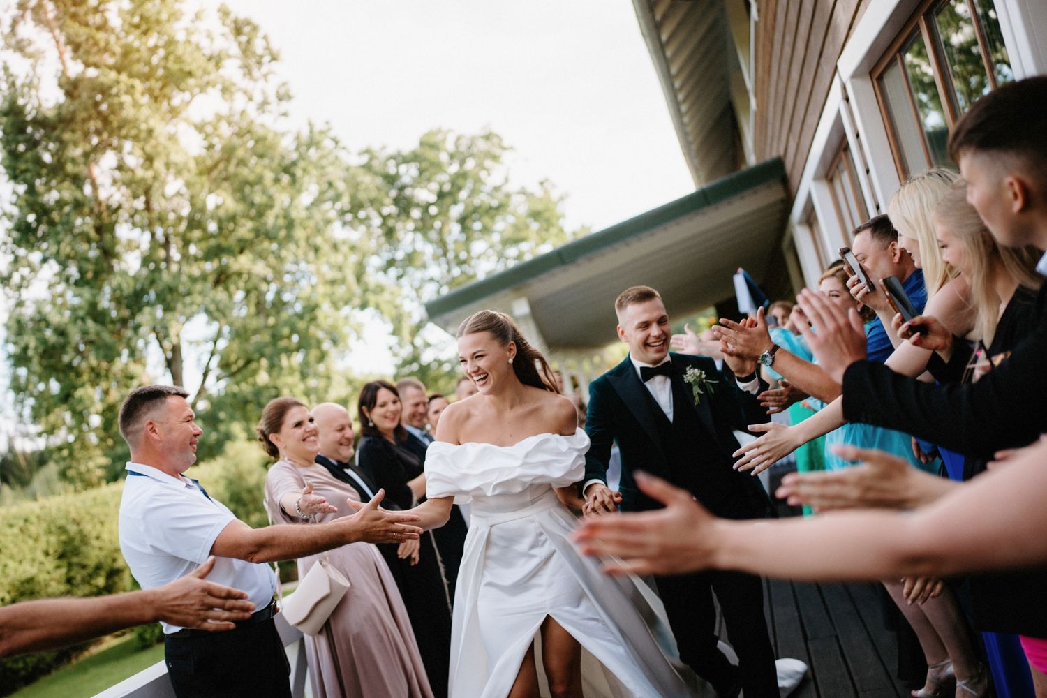 Wedding guests share a fun moment taking shots together during an outdoor reception celebration.