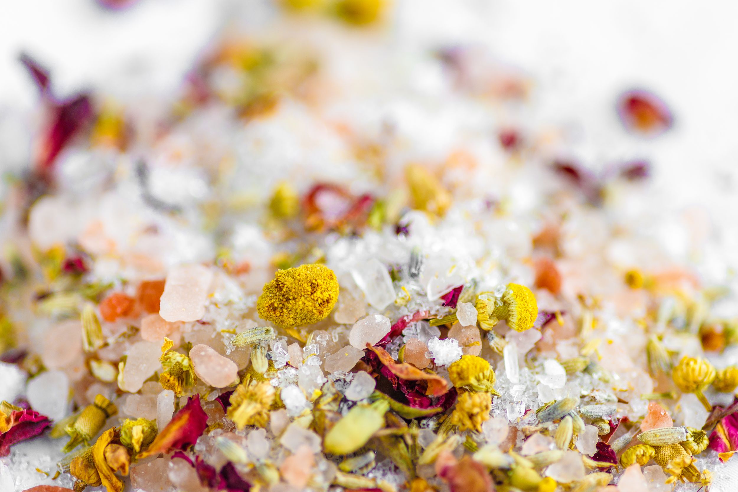 Colorful spices and seasonings scattered on a light background create a vibrant culinary display.