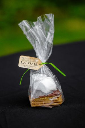 Gift wrapped dessert package with a 'Love' tag and green ribbon on black background.