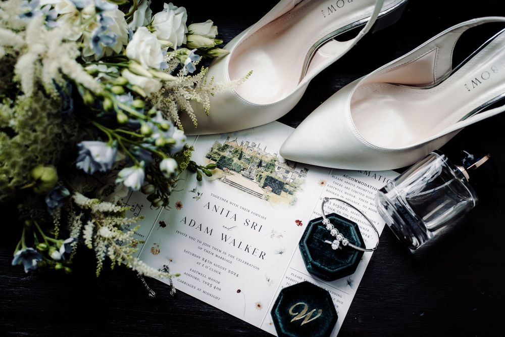 Wedding invitation details with white flowers and champagne bottle.