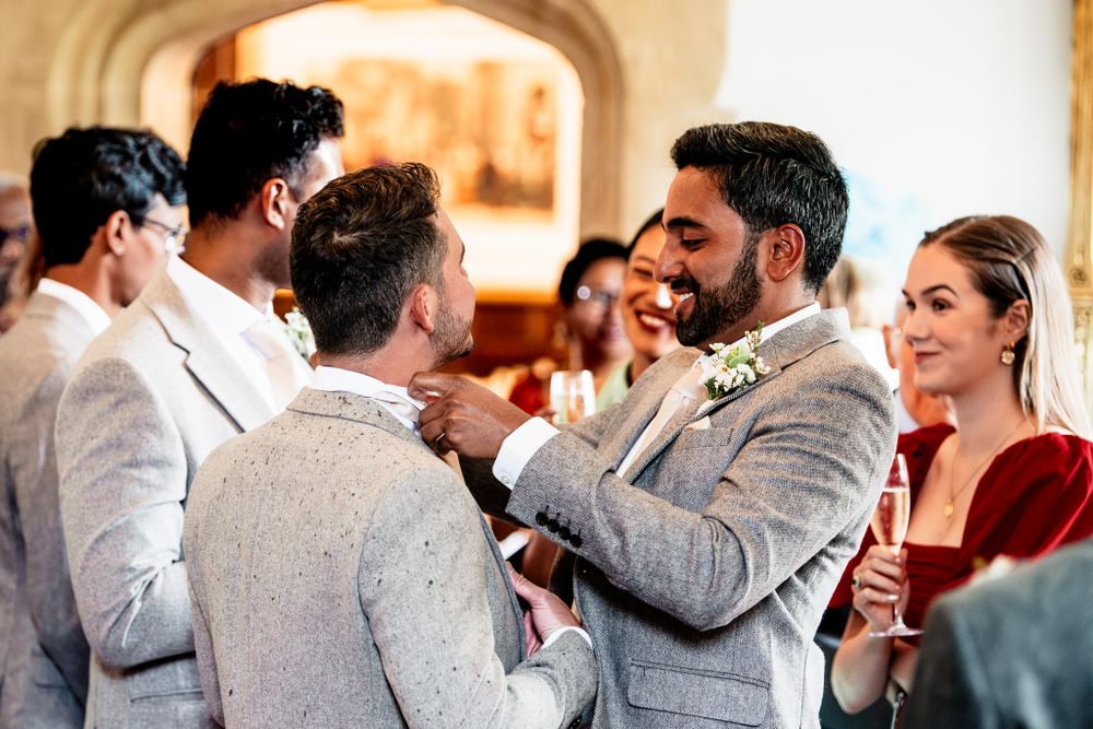Wedding reception scene with guests in formal attire mingling and celebrating.
