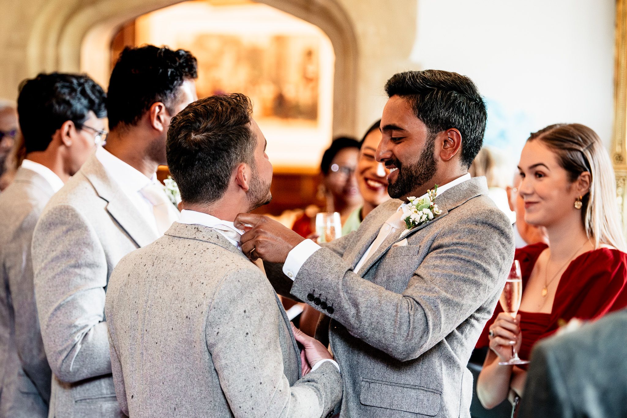 Wedding reception scene with guests in formal attire mingling and celebrating.