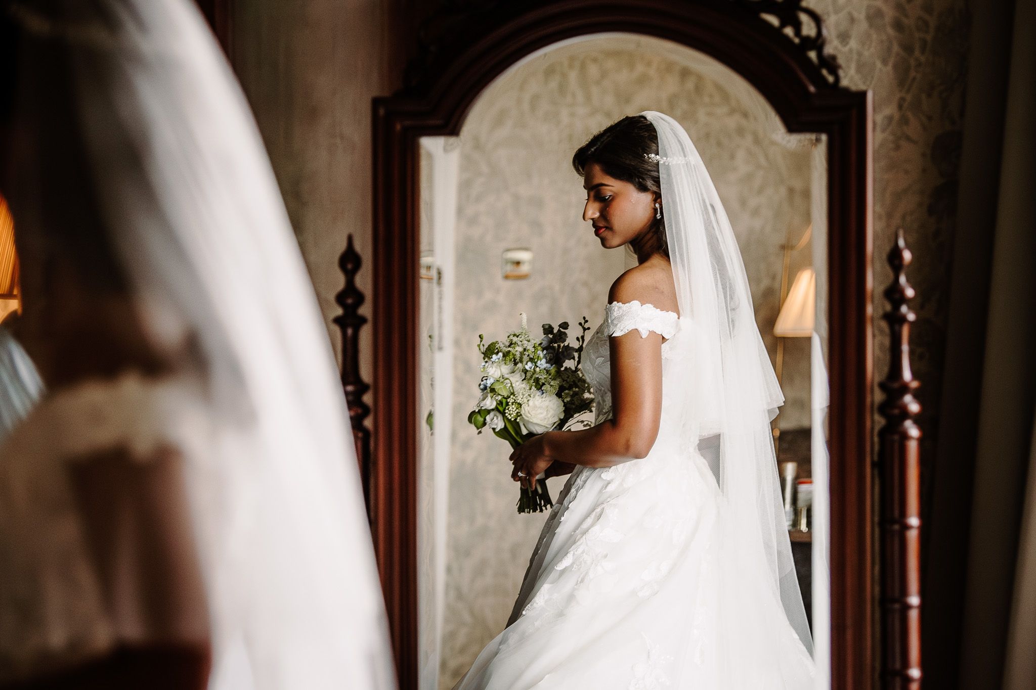 Elegant wedding scene in a dimly lit historic interior hallway.