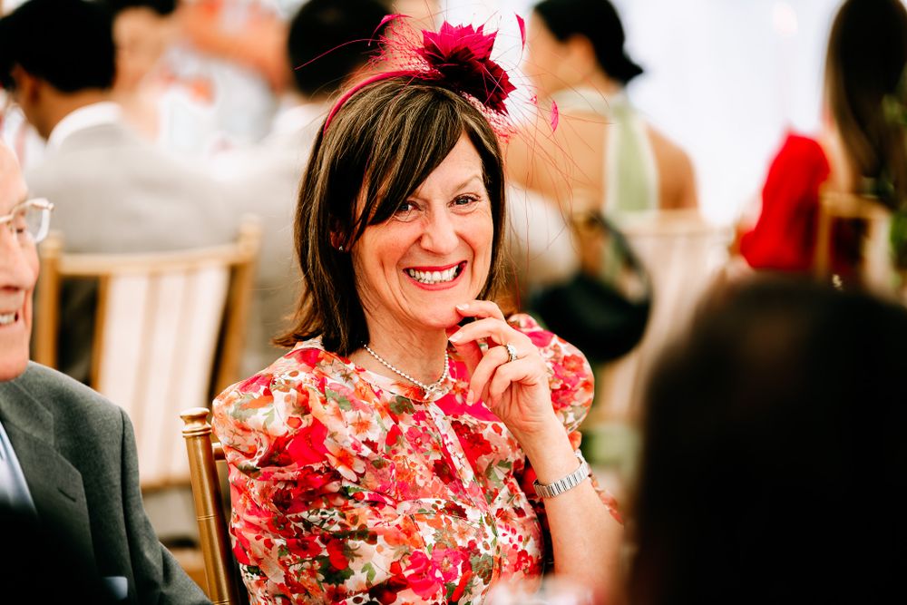 Guests enjoying a lively celebration in formal attire with bright red floral accents.