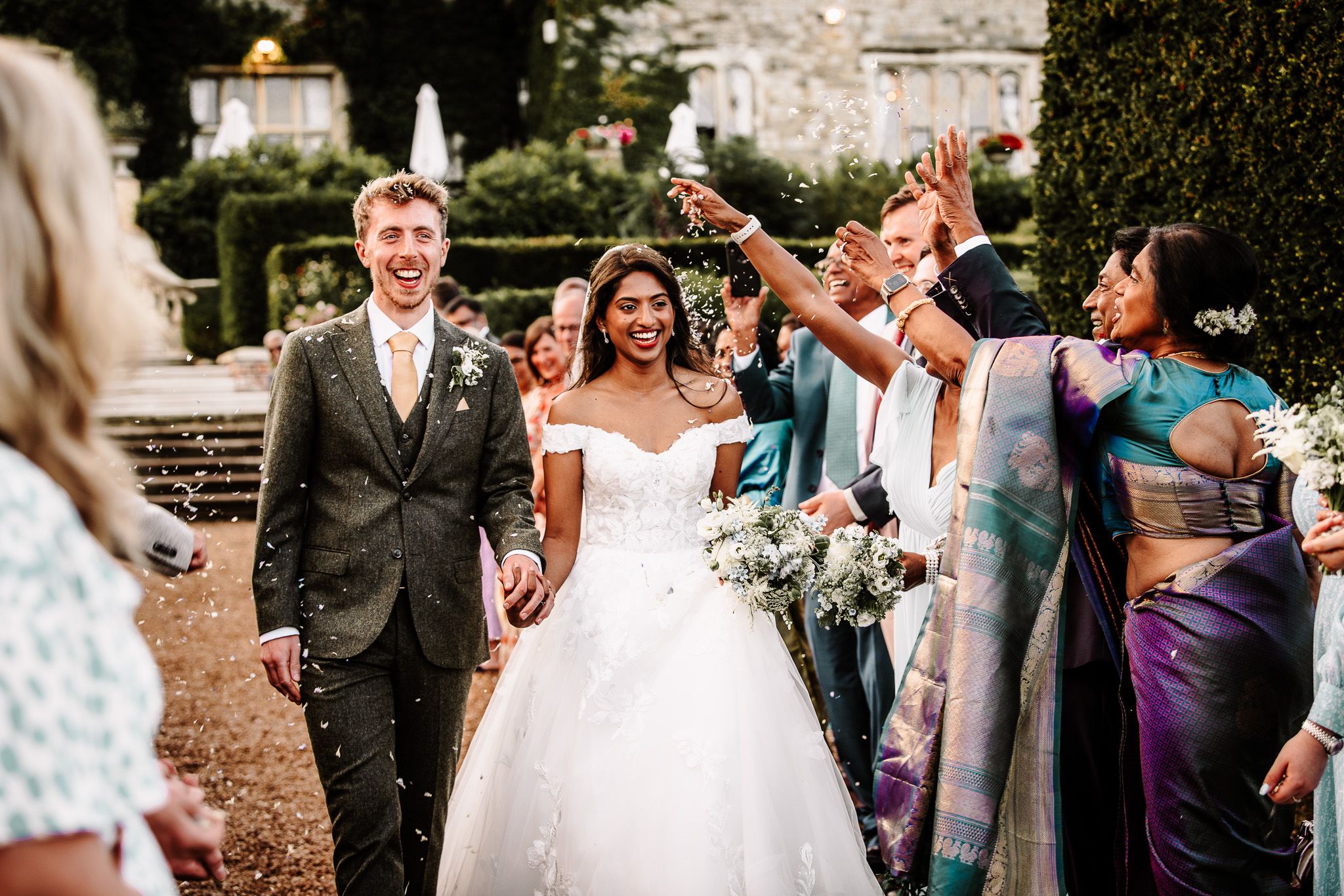 Wedding celebration with guests cheering in an outdoor garden setting.