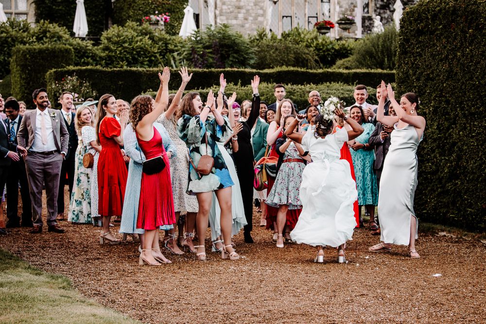Wedding guests line up outdoors for a celebratory reception moment at an elegant venue.