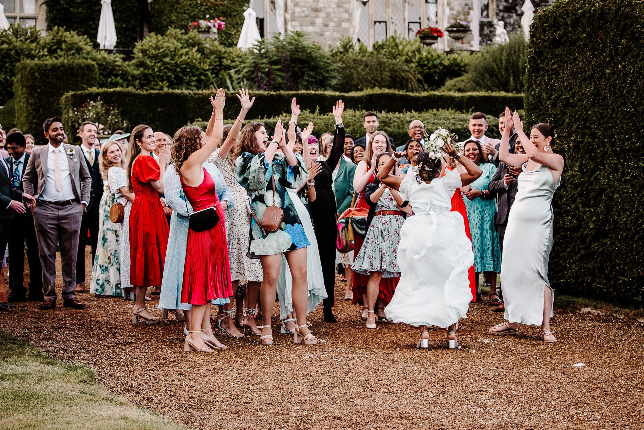 Wedding guests line up outdoors for a celebratory reception moment at an elegant venue.