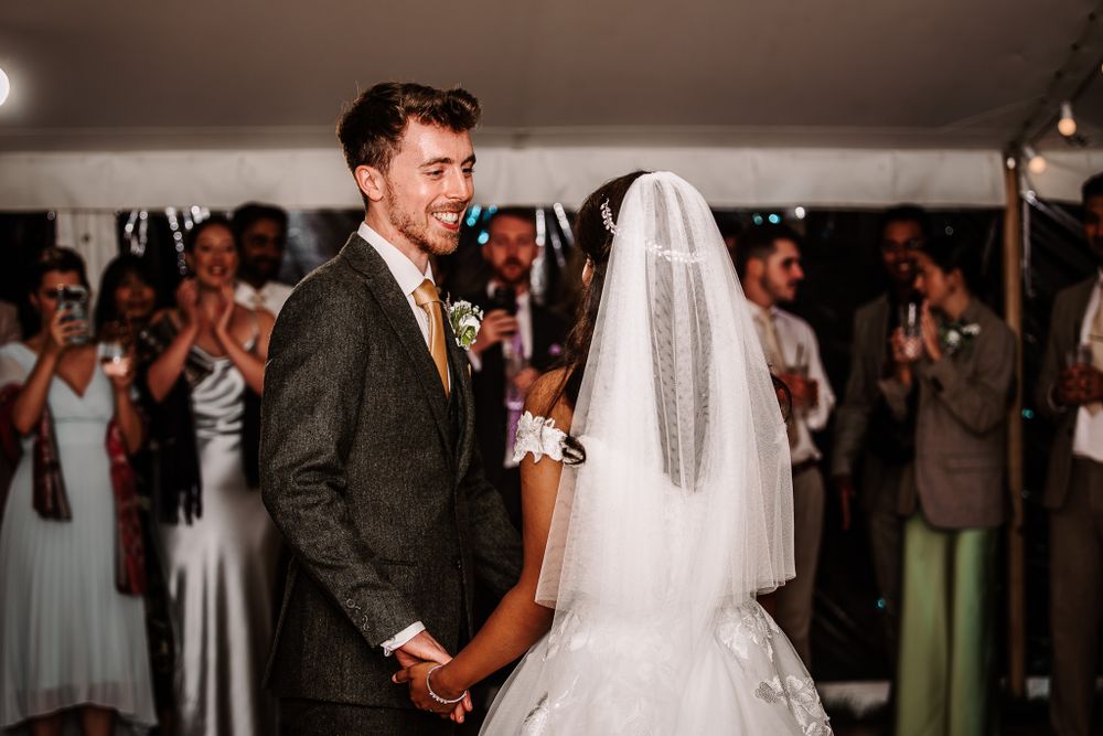 Indoor wedding celebration with guests enjoying festivities in a traditional venue setting.