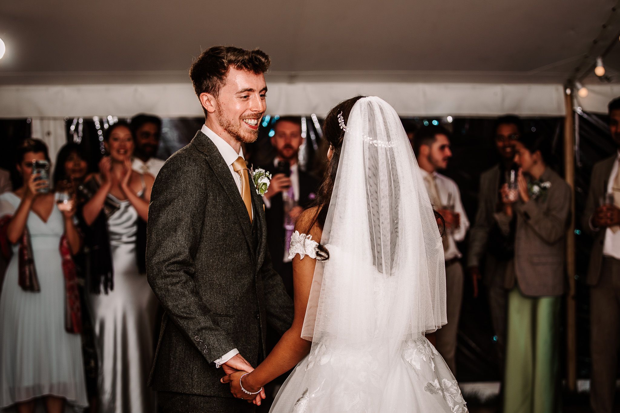 Indoor wedding celebration with guests enjoying festivities in a traditional venue setting.