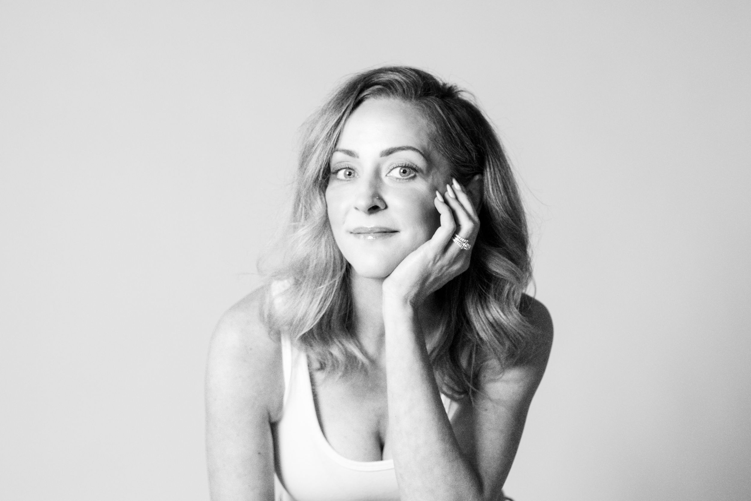 Black and white self-portrait of a woman with soft lighting, posed in thoughtful elegance — studio portrait by Crystal Kellogg Photography,