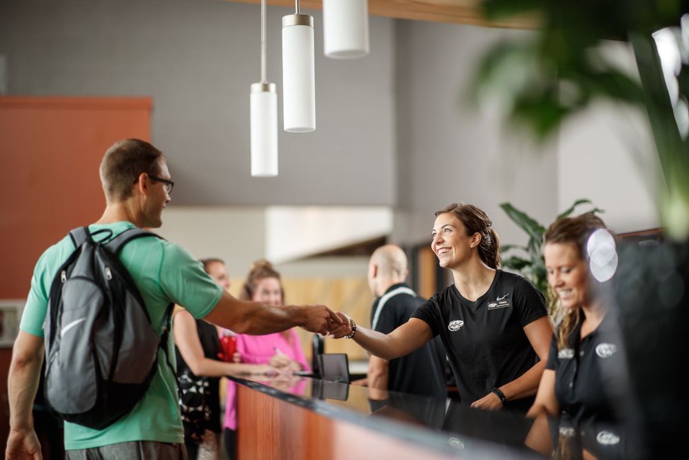 Friendly interaction at gym reception desk.