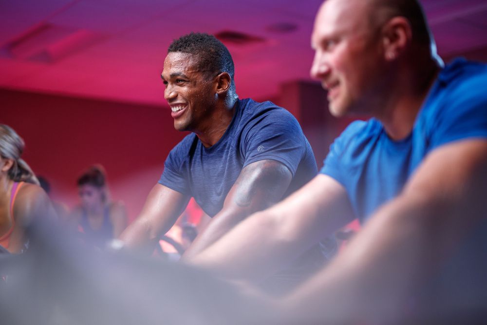 Indoor cycling class with participants on stationary bikes.
