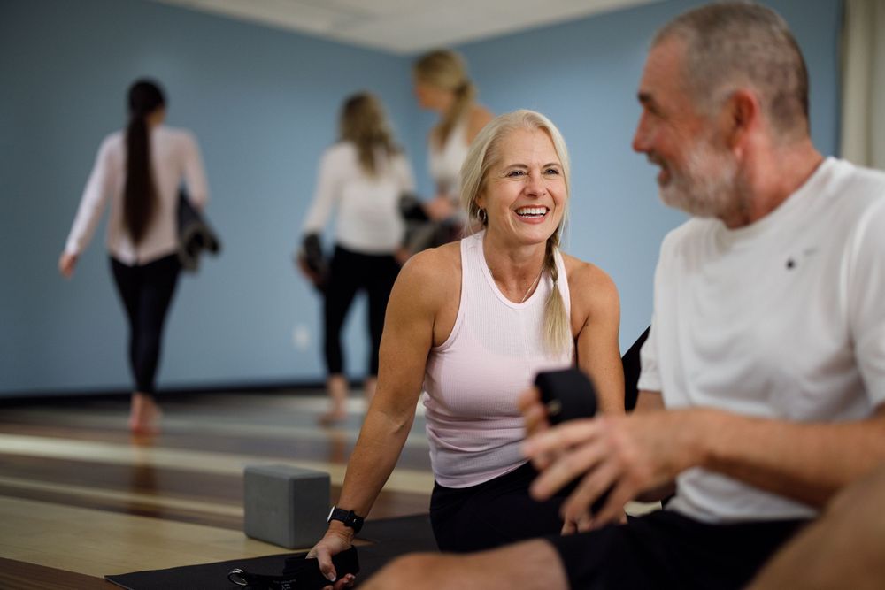 Group enjoying social interaction during fitness class in bright indoor space.