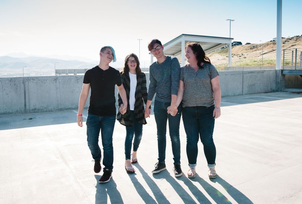 Friends walking together on concrete surface casting long shadows.