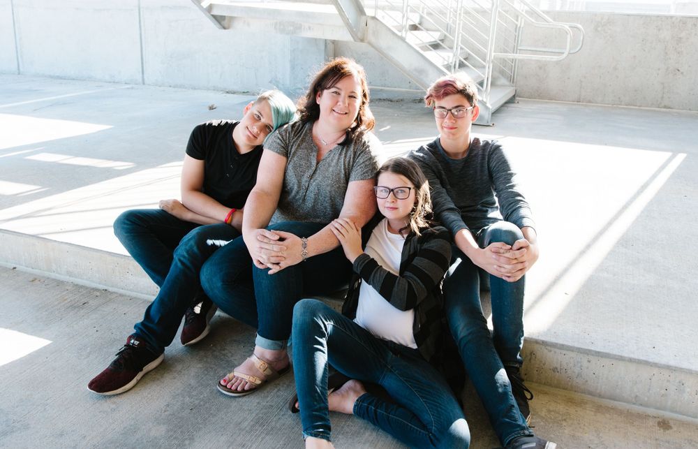 Friends relaxing on outdoor steps in casual urban setting.