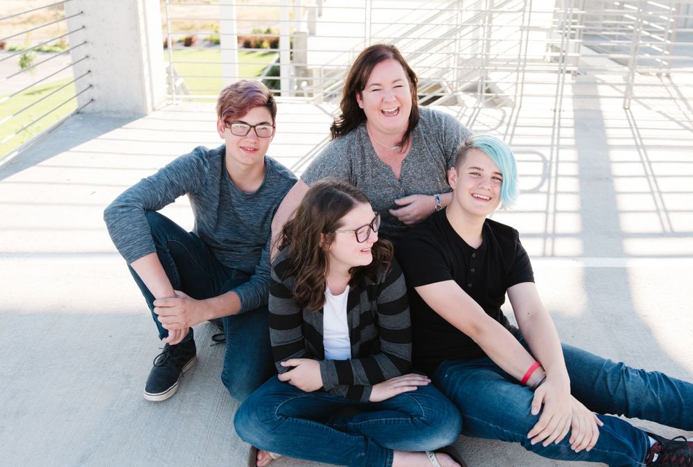 Friends sitting together on concrete steps in casual urban setting.