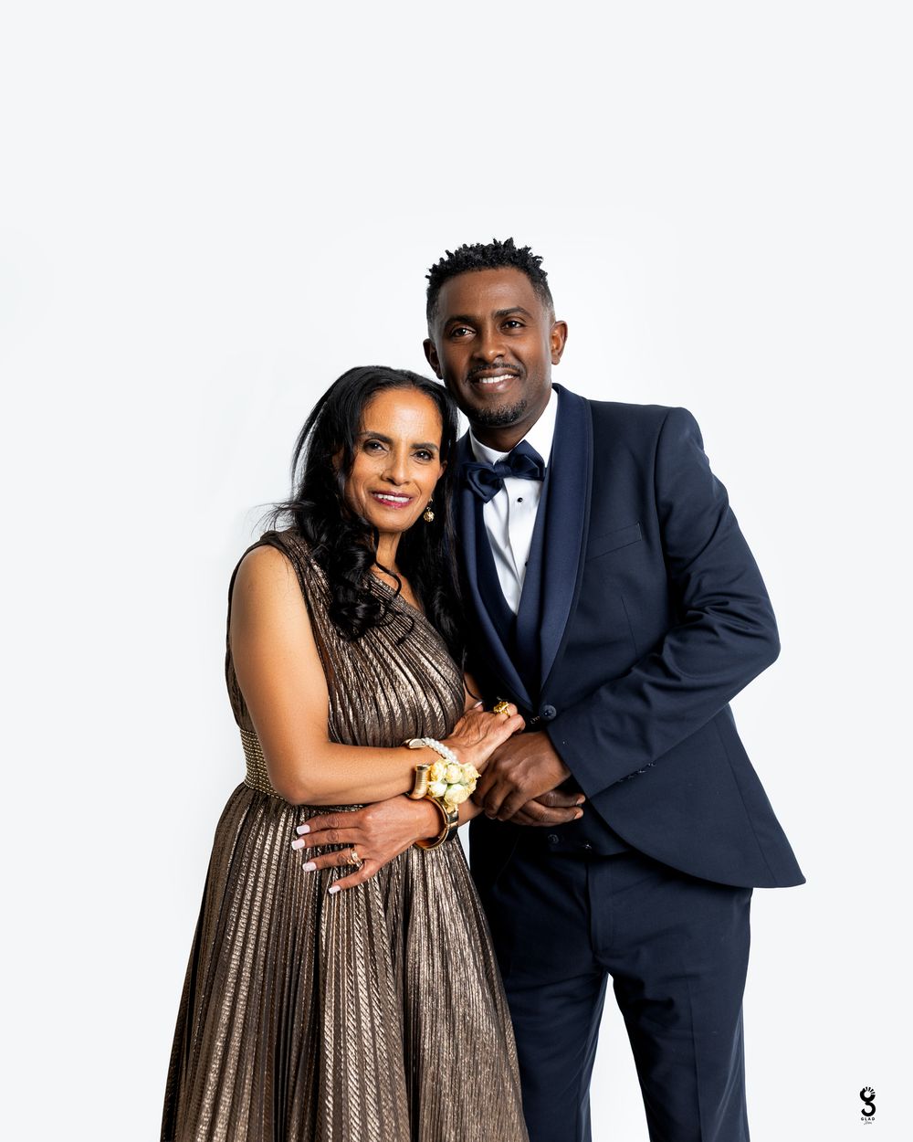 A couple in formal attire poses for three glamorous photos, with the woman in a metallic dress and man in navy suit.