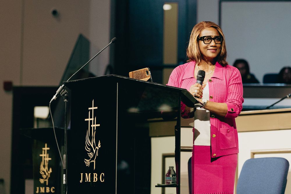 A modern church or conference space with illuminated cross decorations on the walls and pink lighting accents.