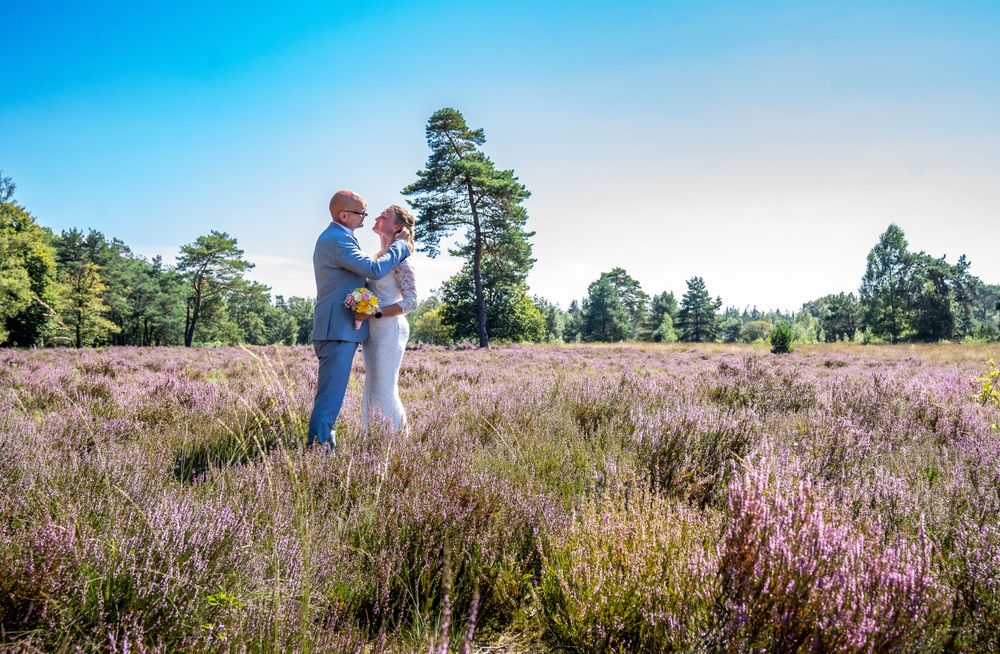 heide natuur zomerse dag trouwen bruid en bruidegom Geen standaard pose ontspannen love trouwpak trouwjurk trouwfotograaf