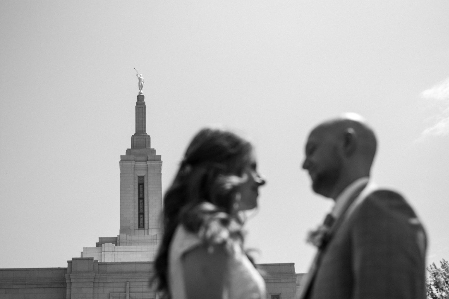 Bride and groom in front of Orem temple on wedding day.