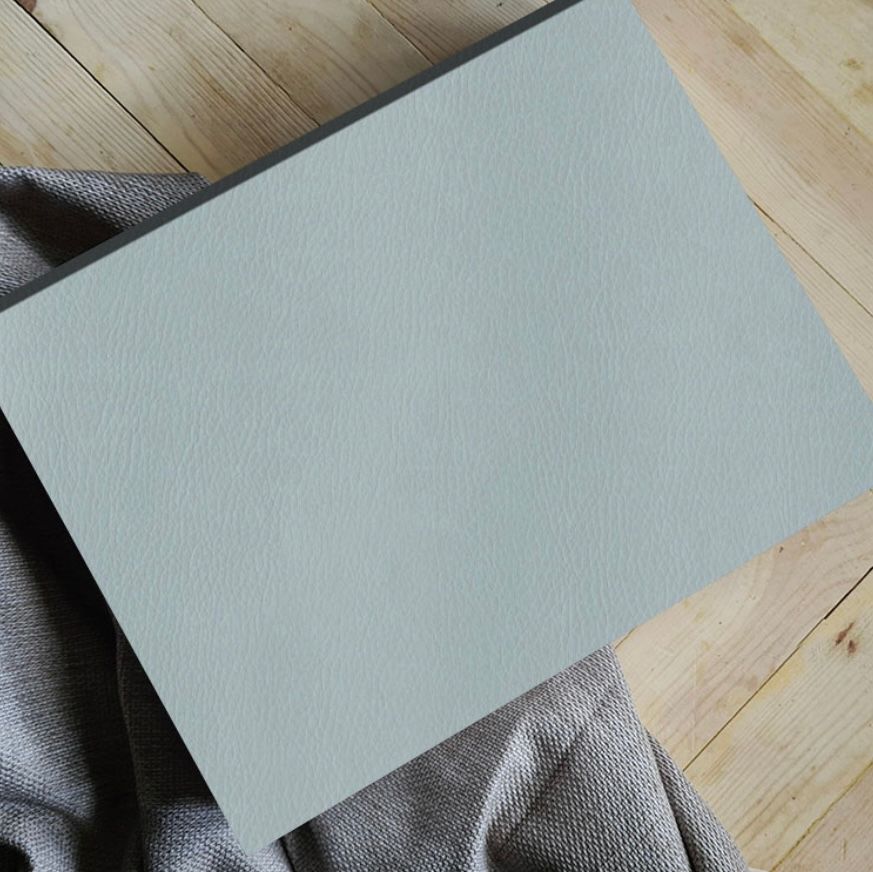 Light blue textured surface against wooden floor background.