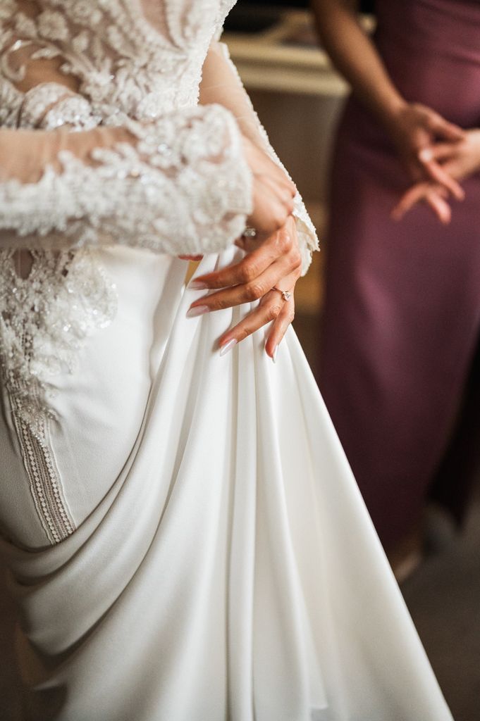 Close-up detail of delicate lace wedding dress with intricate beadwork.