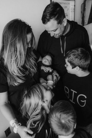 Family looking at newborn for Fresh 48 photography session captured by Maryland Fresh 48 newborn photographer Mallory Bramlett.