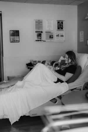Mother in hospital bed with newborn for Fresh 48 photography session captured by Maryland Fresh 48 newborn photographer Mallory Bramlett.