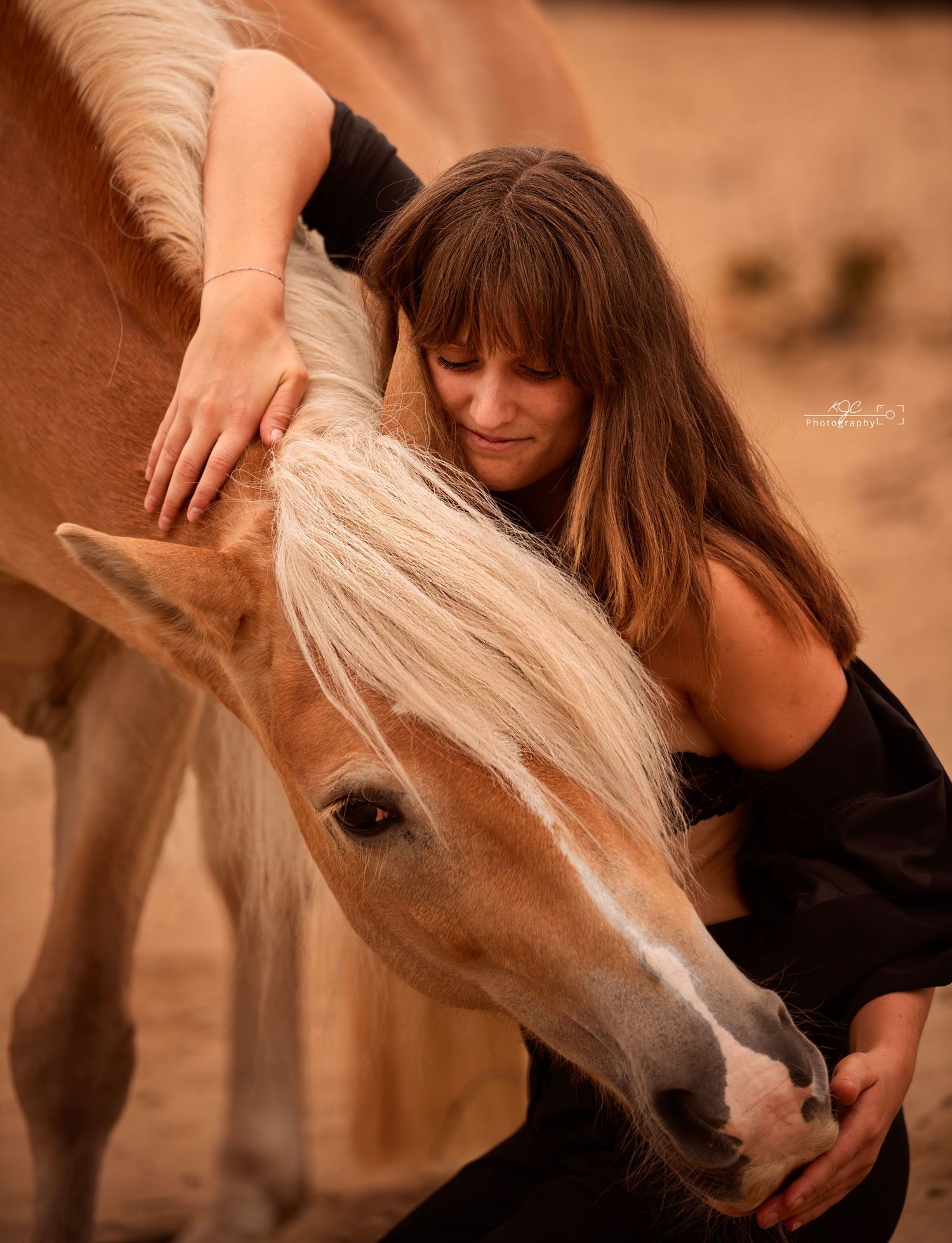 Liefdevolle aanraking en omhelzing van jong vrouw aan paard. Prachtig in warme sferen vastgelegd door paardenfotografe