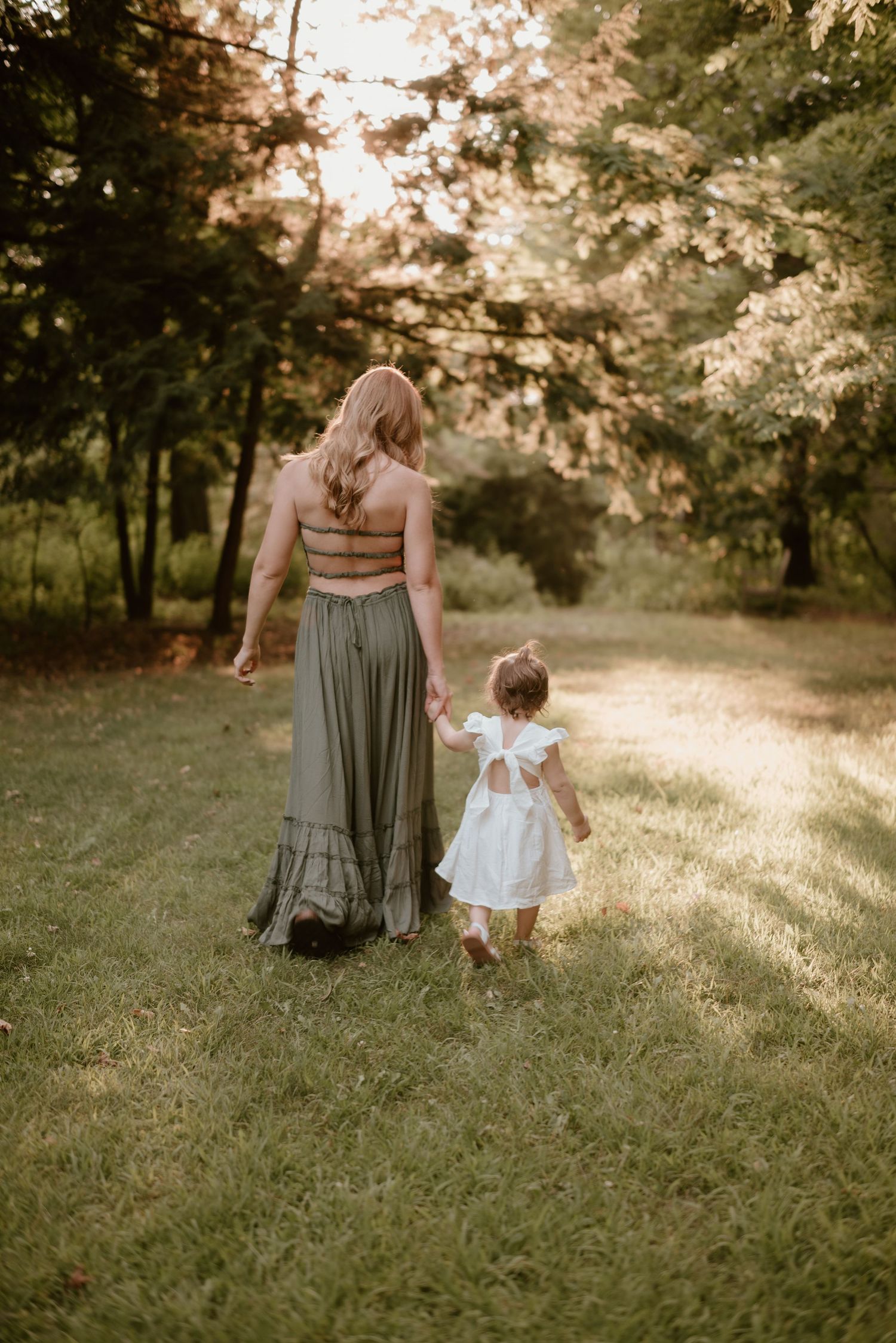 Family with a young child sharing a joyful moment among pine trees in a forest.