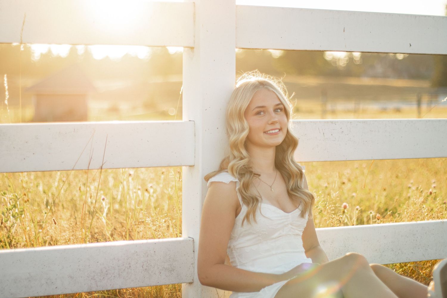 Cora Emilie Media -A person stands on a hillside with mountains and forest in the background.