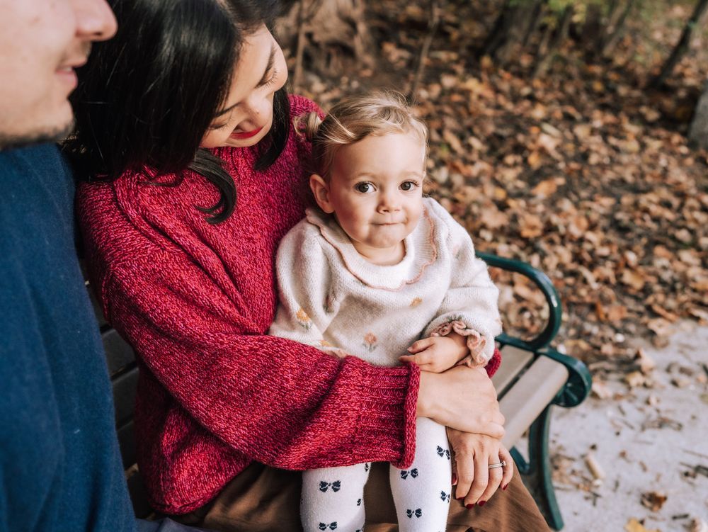 A series of candid autumn family photos showing tender moments between parent and child on fallen leaves.