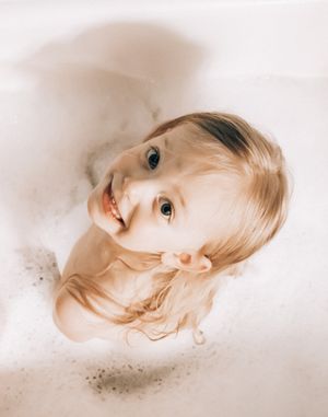 Artistic milk bath photography with soft lighting and ethereal white tones.
