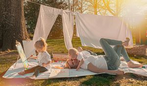 White blanket fort set up outdoors during golden sunset in a backyard.
