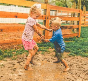 Action shots of people running and playing in a muddy fenced area.