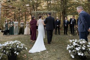 Outdoor fall wedding at Farmer Brown's Greenhouse, bride walks down the aisle with parents during wedding ceremony processional, Moncton