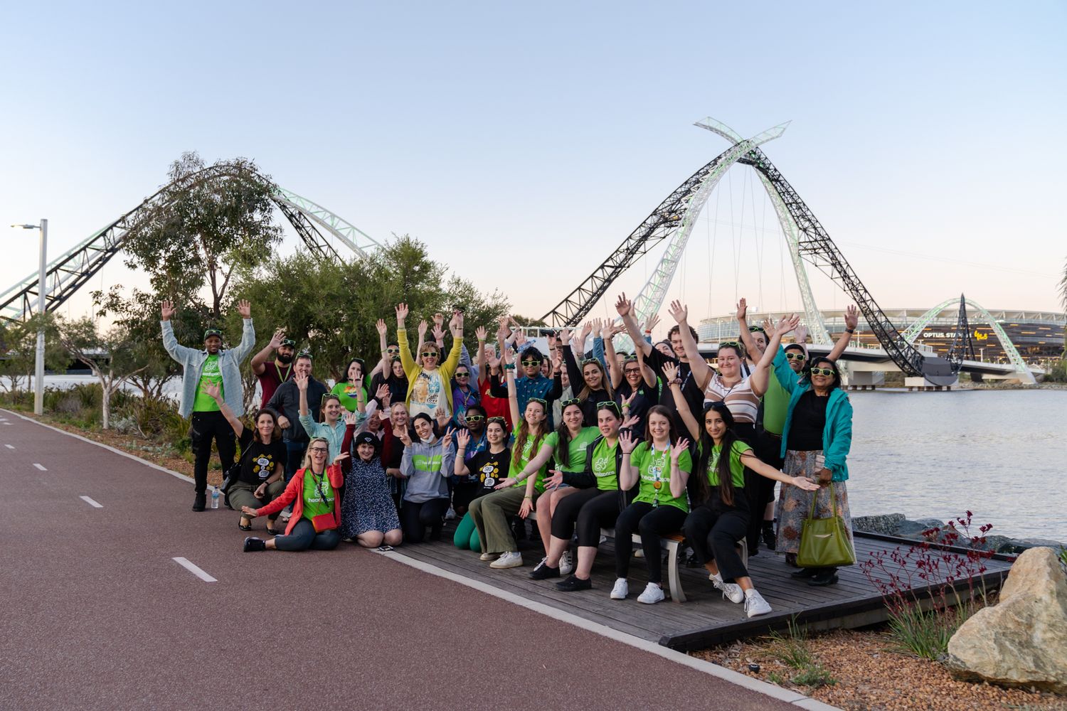 Large group of people in colorful attire gathered outdoors near architectural structures.